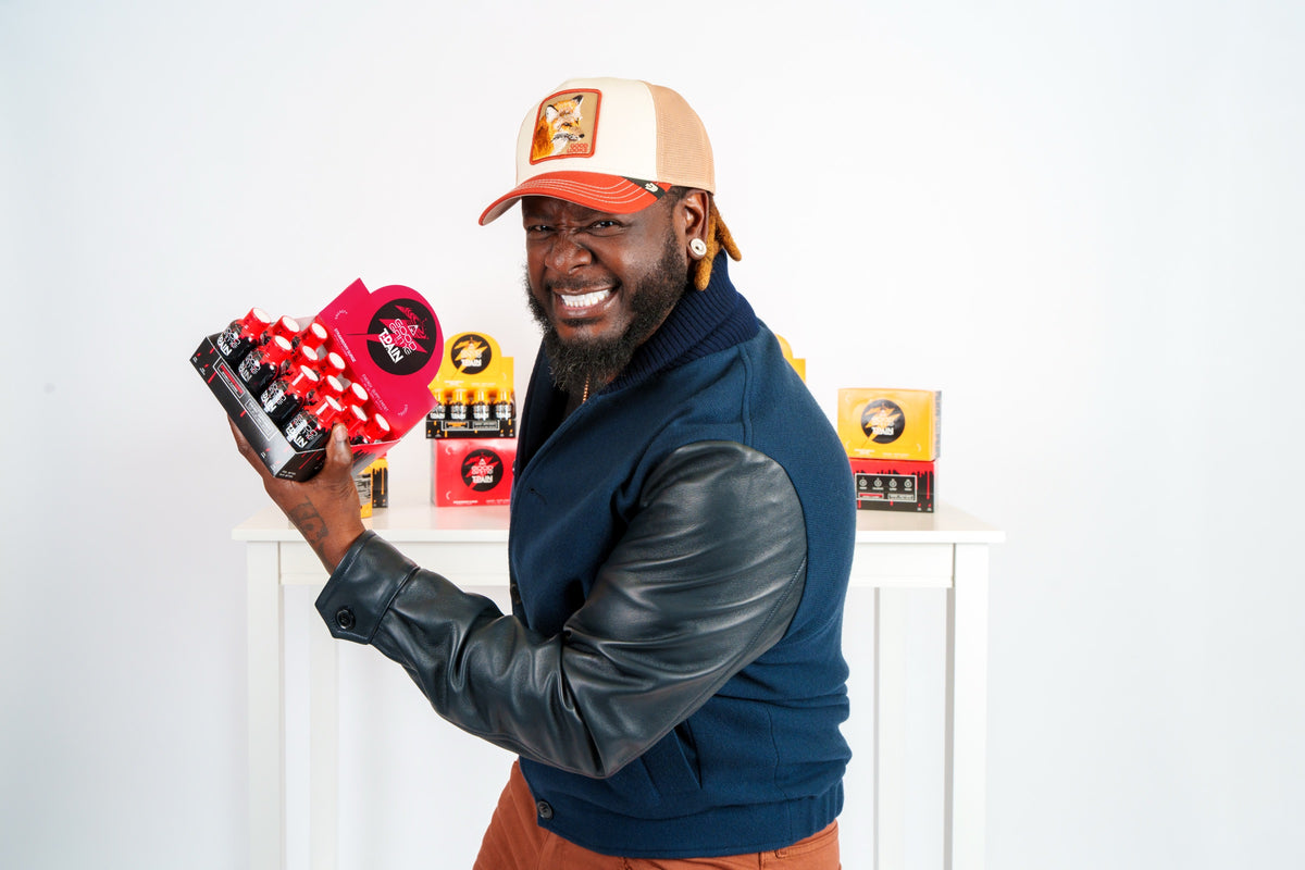 T-Pain, co-founder and CEO of Nappy Boy Dranks, holding a Good Game energy shot 12-pack